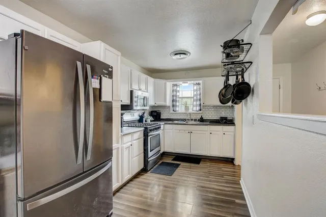 a kitchen with white cabinets and stainless steel appliances