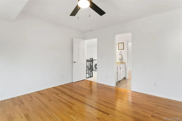 a view of a big room with wooden floor and windows