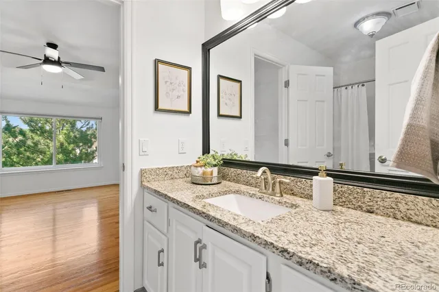 a bathroom with a granite countertop sink and a large mirror