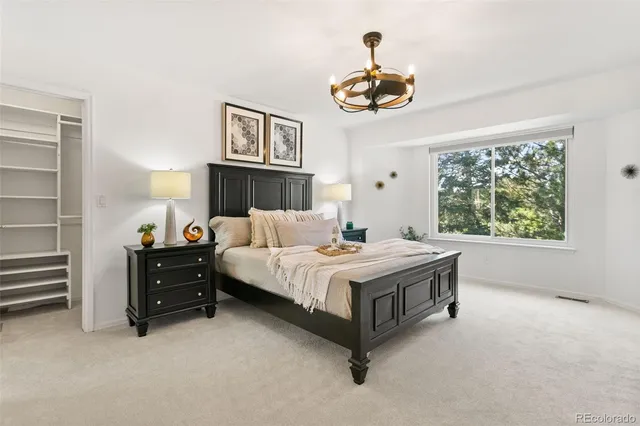 a spacious bedroom with a bed and a chandelier