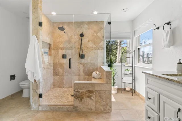 a bathroom with a granite countertop shower a sink and a mirror