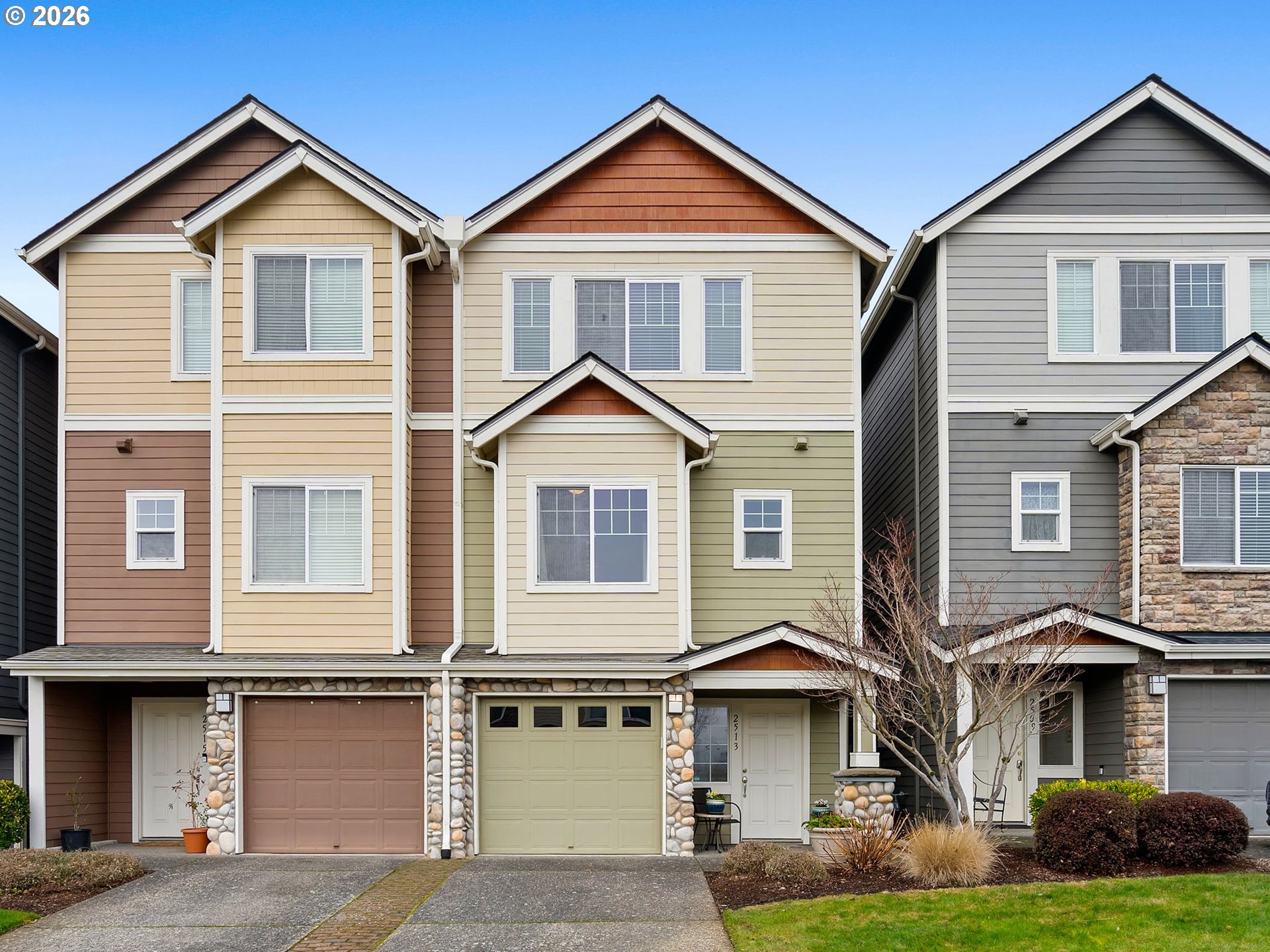 a view of a white house with large windows and a yard