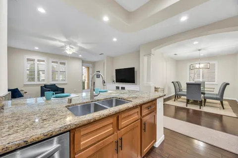 a kitchen with stainless steel appliances granite countertop a sink stove and wooden floor