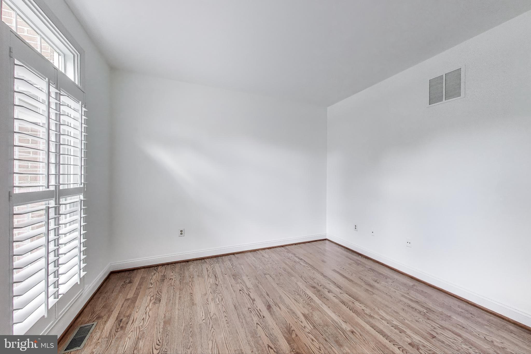 10106 Waterside Drive Burke, VA 22015 - Photo 11 of 30 a view of an empty room with wooden floor and a window