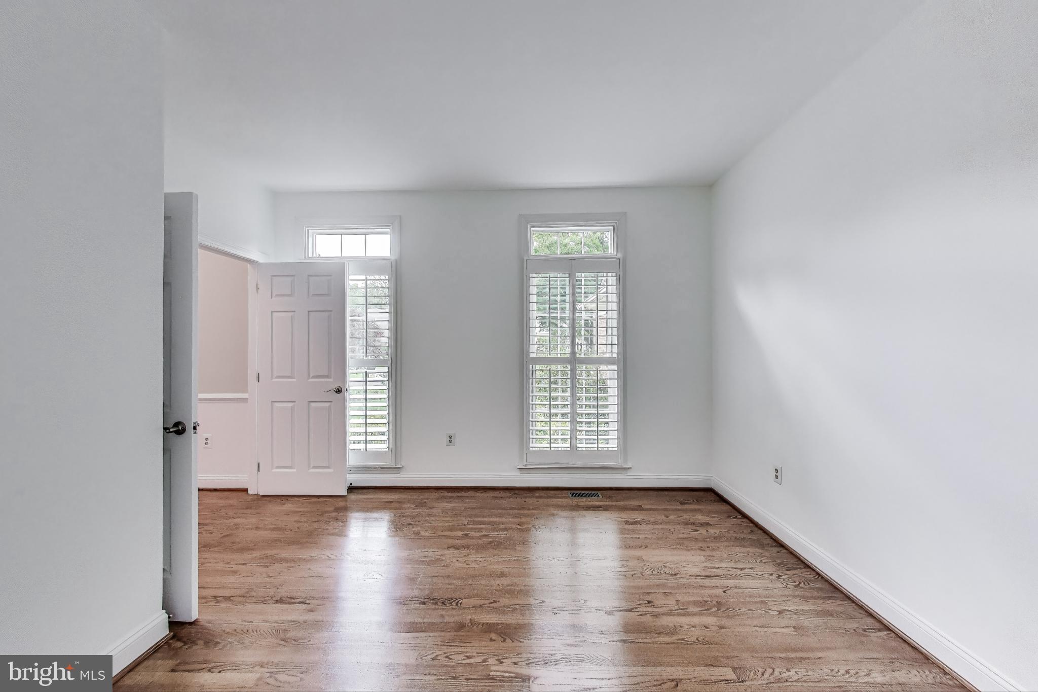 10106 Waterside Drive Burke, VA 22015 - Photo 10 of 30 an empty room with wooden floor and windows