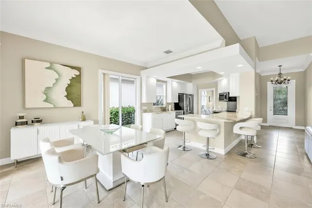 a dining room with furniture and large windows