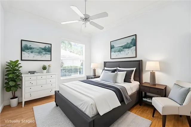 a bedroom with a large bed and a chandelier fan