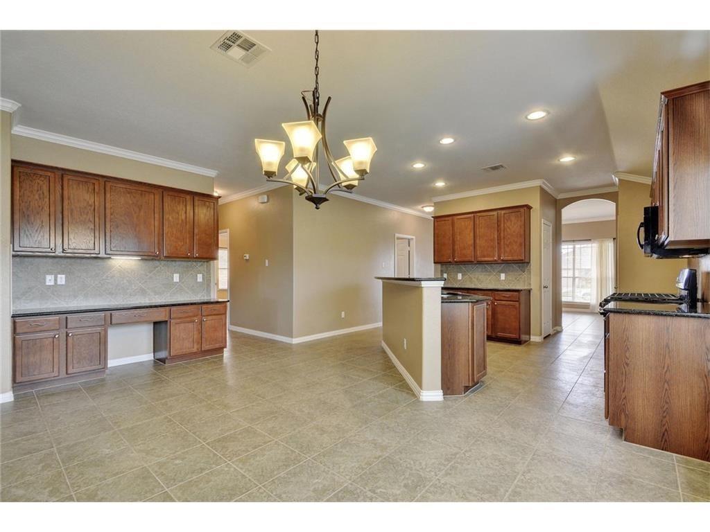 2109 Granite Springs Road Leander, TX 78641 - Photo 6 of 30 A well-appointed kitchen and dining area features abundant cabinetry and a stylish breakfast bar.
