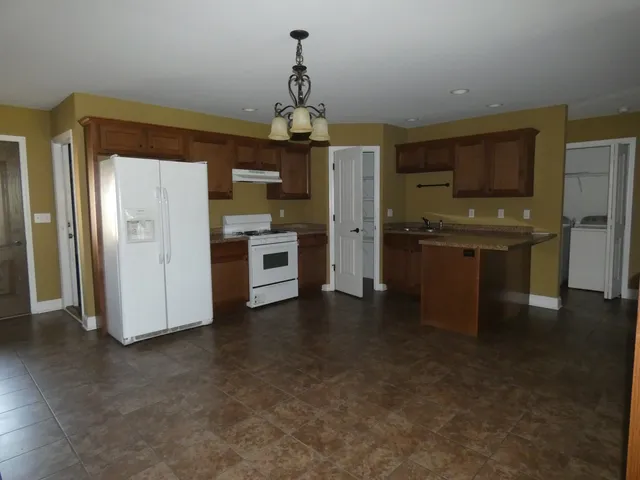 a kitchen with kitchen island stainless steel appliances a sink stove and refrigerator