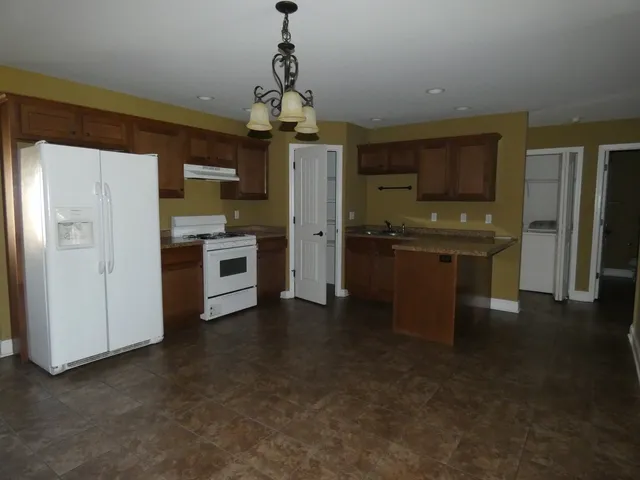 a view of a kitchen with a sink stove and refrigerator