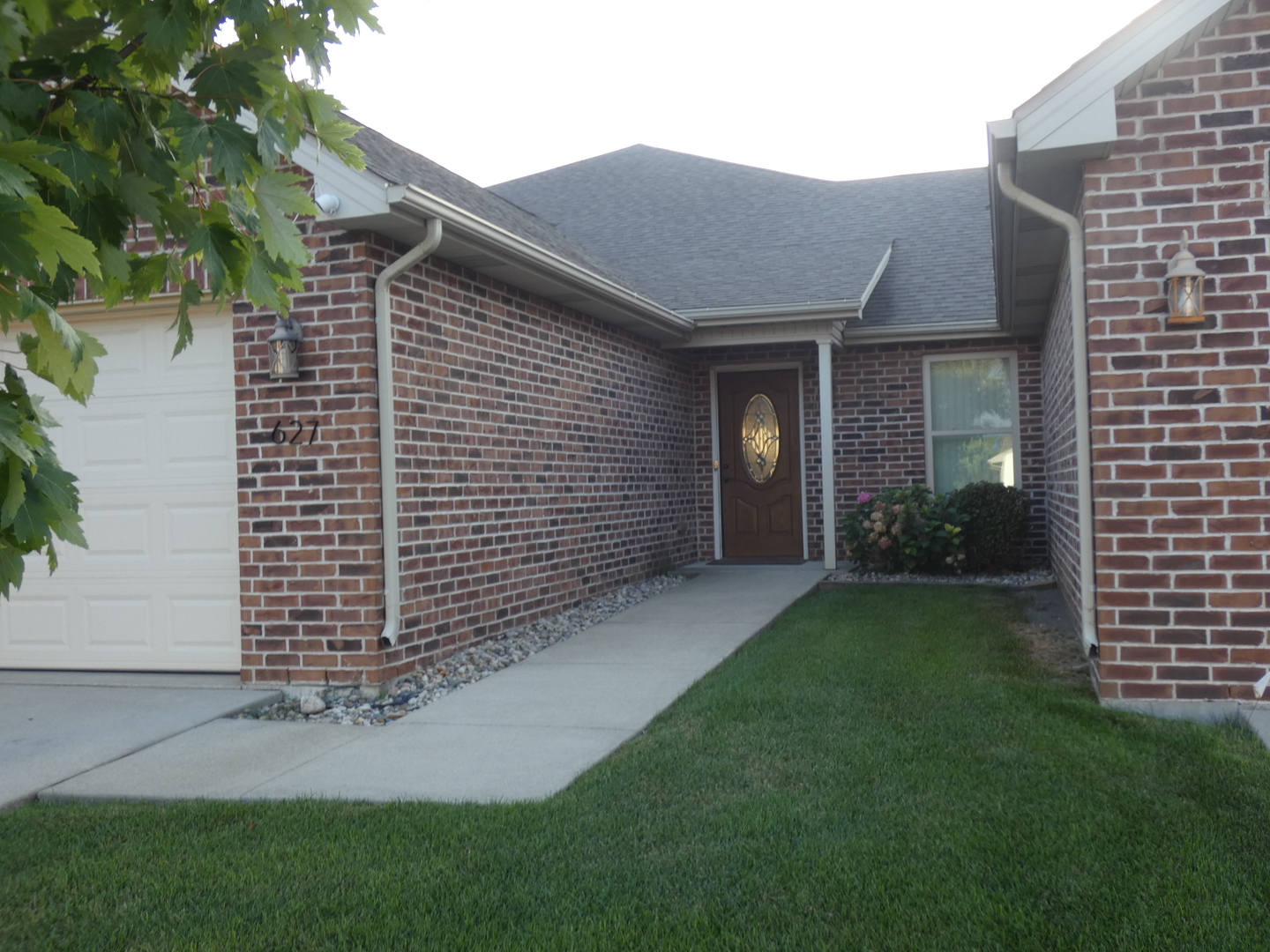 627 North Edgemere Drive Bourbonnais, IL 60914 - Photo 2 of 37 a view of a brick house with a yard and large tree
