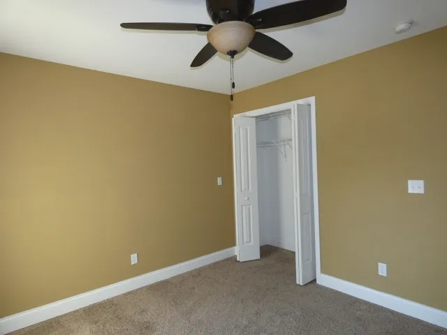 a bathroom with a granite countertop sink a toilet and mirror