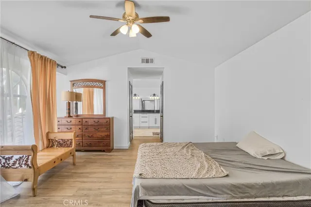 a bedroom with a bed and wooden floor