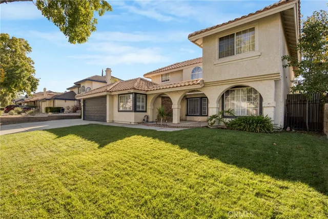 a front view of a house with swimming pool lawn chairs and yard