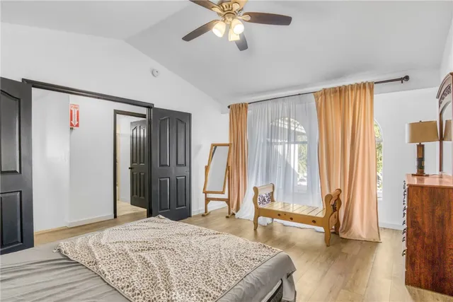 a spacious bedroom with a large bed and a chandelier