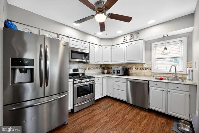 a kitchen with stainless steel appliances granite countertop a refrigerator a stove a sink and a refrigerator