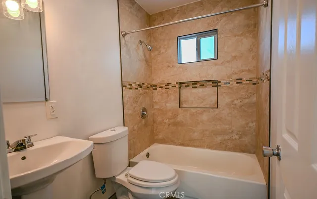 a white toilet sitting next to a bath tub