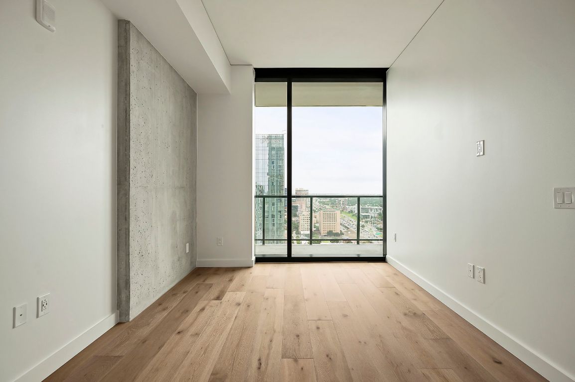 610 Davis Street, Unit 2812 Austin, TX 78701 - Photo 13 of 32 an empty room with wooden floor and windows