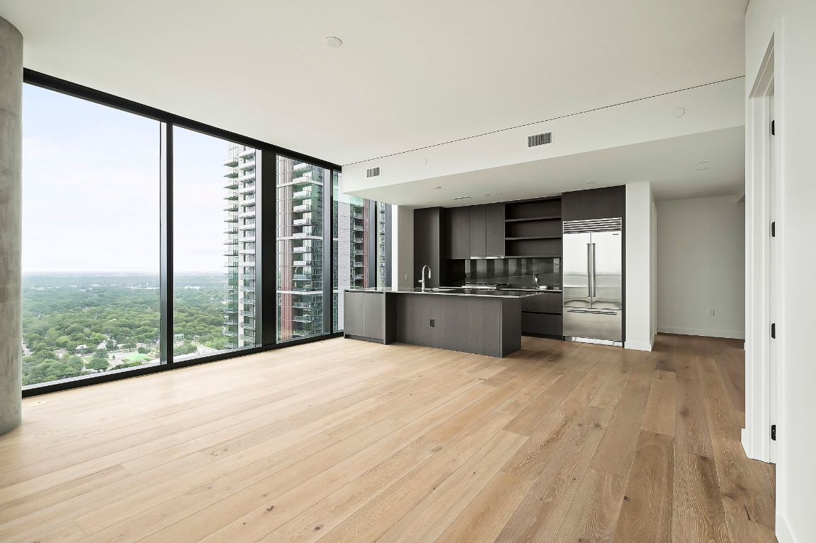 610 Davis Street, Unit 2812 Austin, TX 78701 - Photo 6 of 32 a large white room with kitchen view and wooden floor