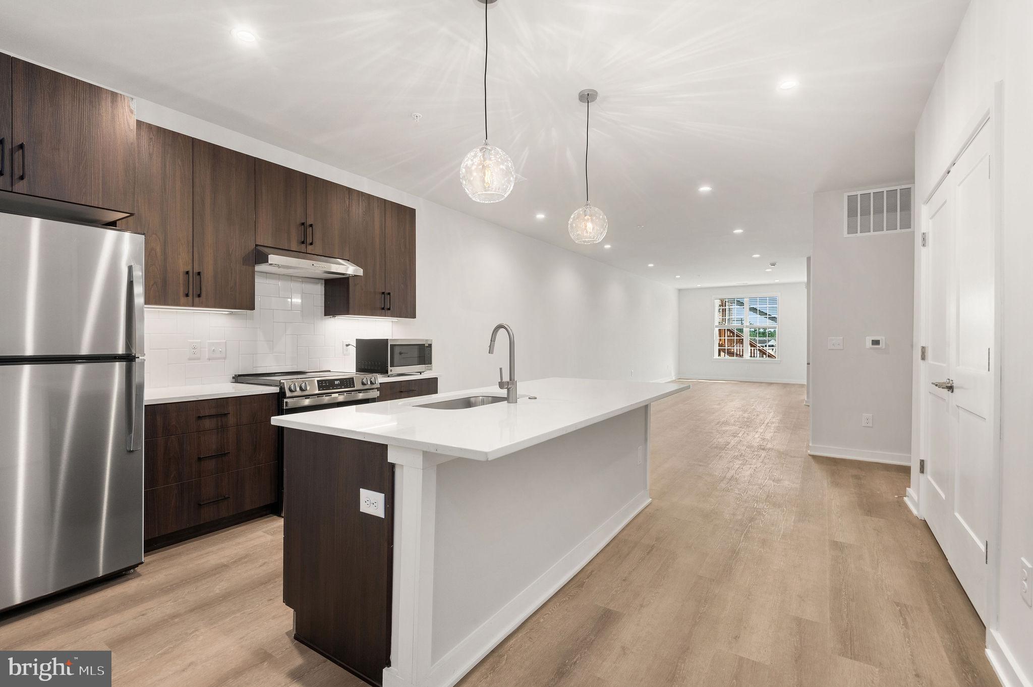 a kitchen with kitchen island a sink stainless steel appliances and cabinets
