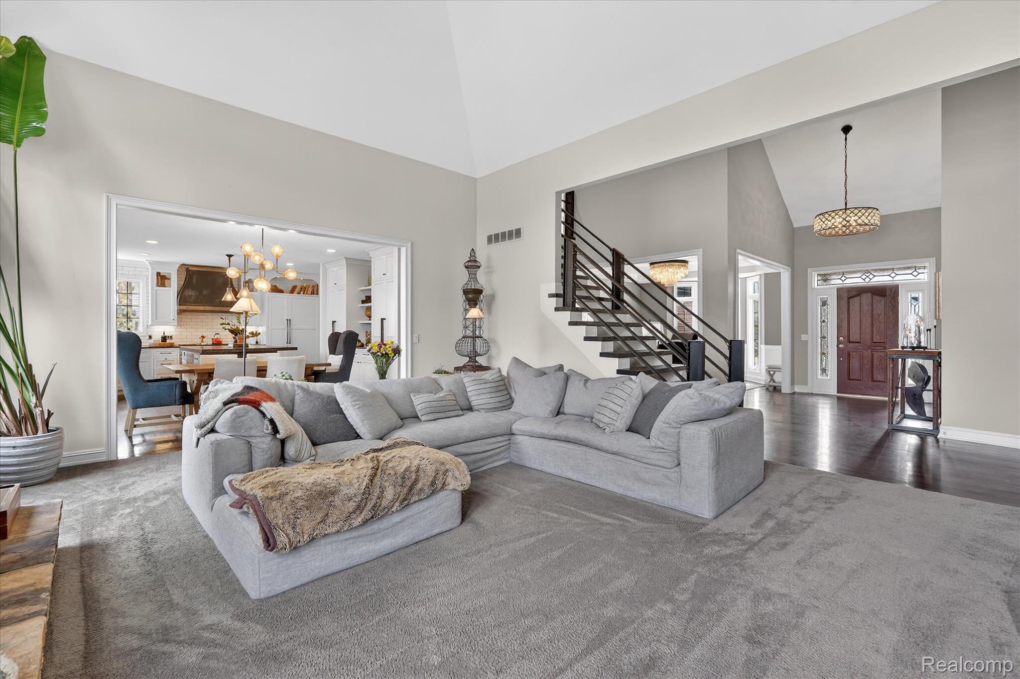 6932 Oakhurst Ridge Road Clarkston, MI 48348 - Photo 12 of 78 Living room featuring hanging lights and vaulted ceiling