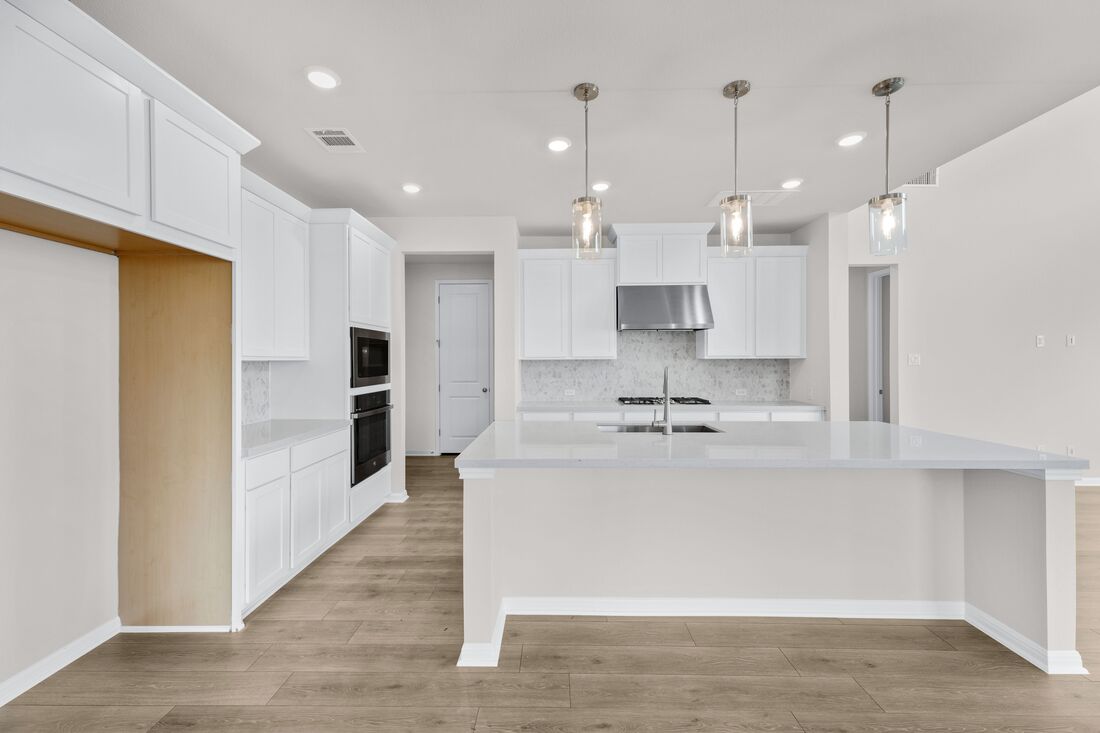 1821 Plum Tree Way Georgetown, TX 78628 - Photo 12 of 35 a large white kitchen with lots of counter space wooden floor and appliances
