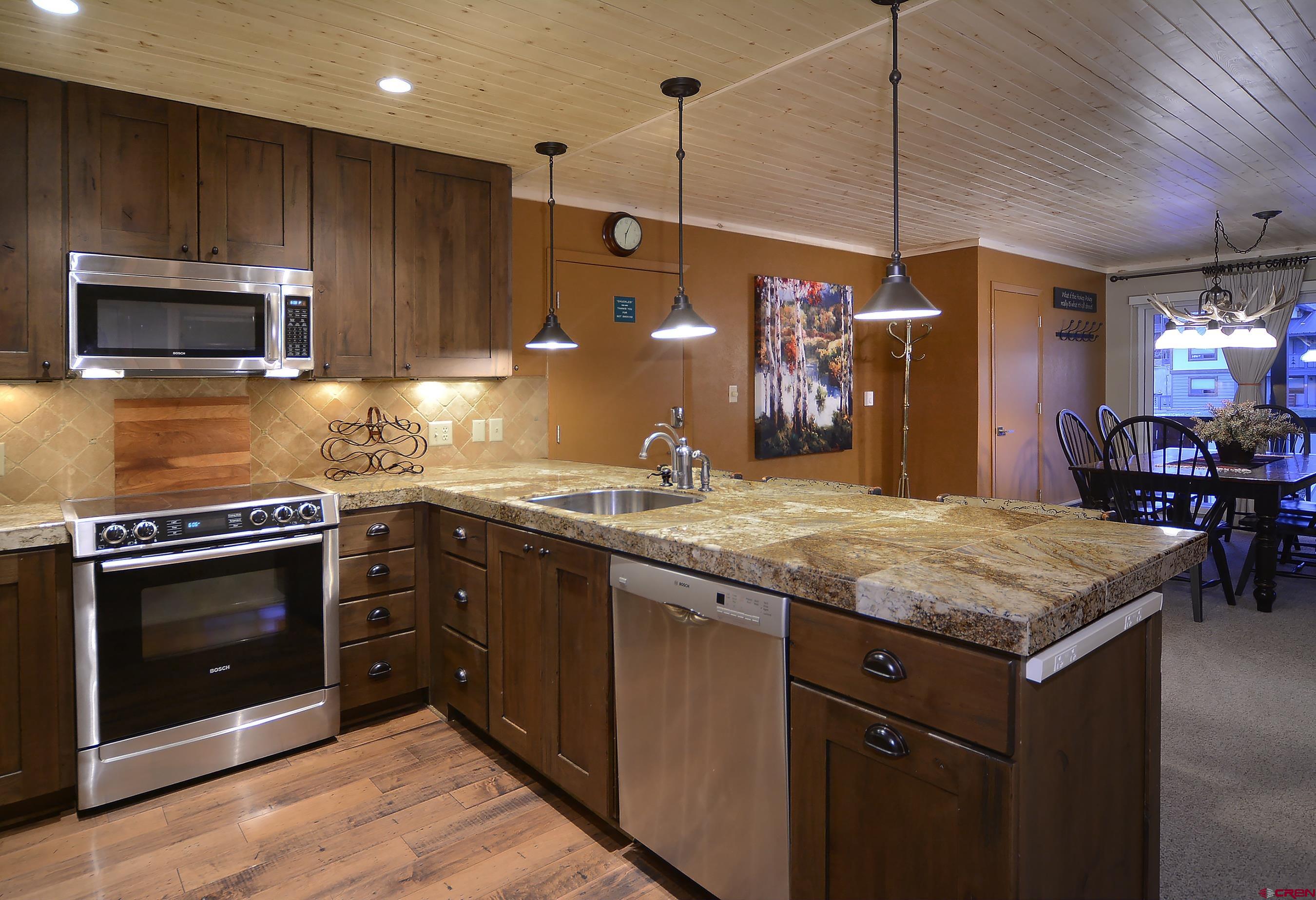 35 Emmons Road, Unit 3 Crested Butte, CO 81225 - Photo 14 of 25 a kitchen with kitchen island granite countertop stainless steel appliances and wooden cabinets