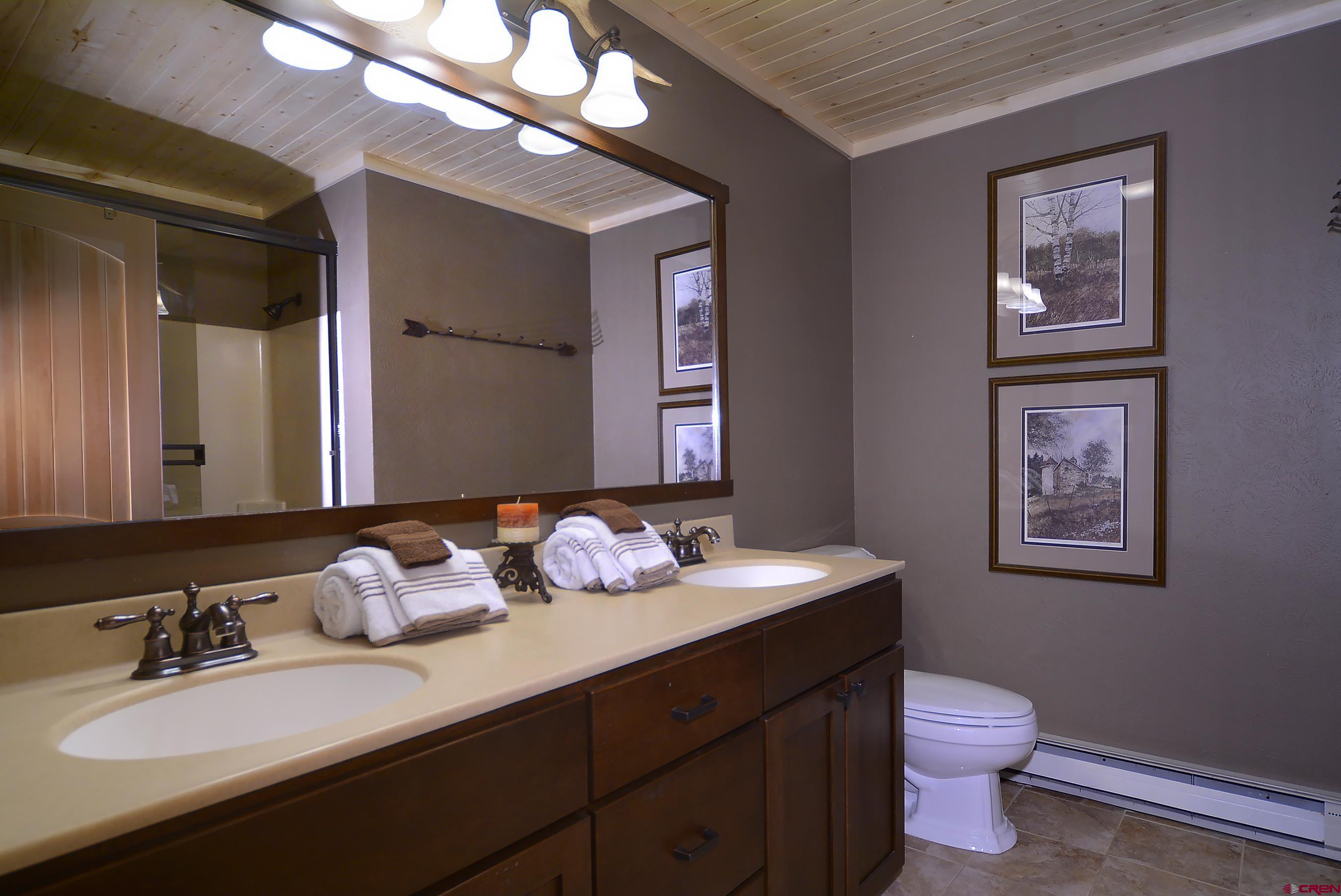 35 Emmons Road, Unit 3 Crested Butte, CO 81225 - Photo 17 of 25 a bathroom with a granite countertop sink a large mirror and a toilet