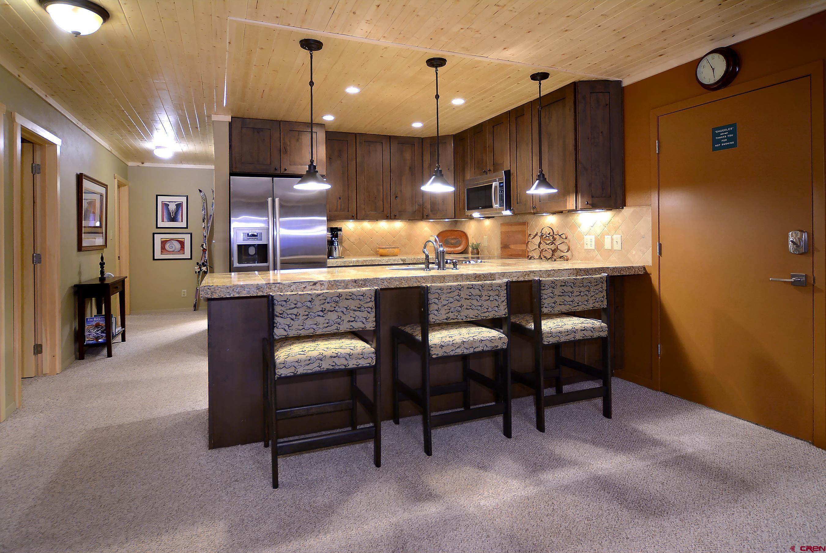 35 Emmons Road, Unit 3 Crested Butte, CO 81225 - Photo 10 of 25 a kitchen with kitchen island a table chairs sink and cabinets
