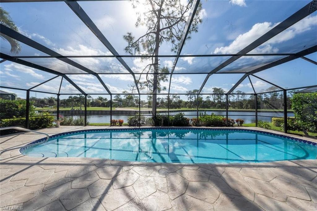 43 Grey Wing Point Naples, FL 34113 - Photo 1 of 50 Swimming pool featuring a sunroom, glass enclosure, a water view, and a patio