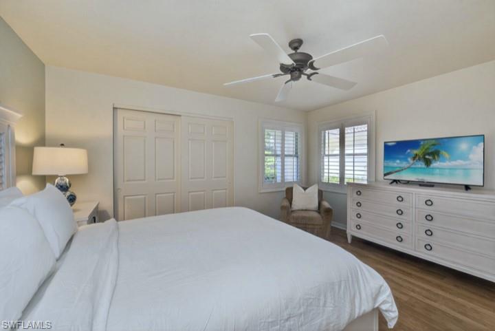 43 Grey Wing Point Naples, FL 34113 - Photo 15 of 50 Bedroom featuring dark wood-style flooring, ceiling fan, and a closet