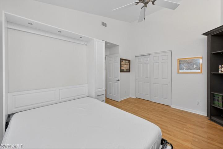 43 Grey Wing Point Naples, FL 34113 - Photo 16 of 50 Bedroom featuring light wood-type flooring, a closet, a ceiling fan, and a high ceiling