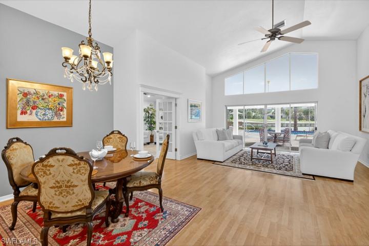 43 Grey Wing Point Naples, FL 34113 - Photo 19 of 50 Dining area featuring high vaulted ceiling, light wood finished floors, ceiling fan, and a chandelier