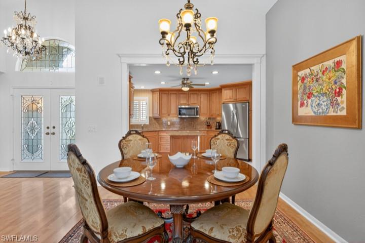 43 Grey Wing Point Naples, FL 34113 - Photo 20 of 50 Dining room featuring a chandelier, light wood-style floors, french doors, and recessed lighting