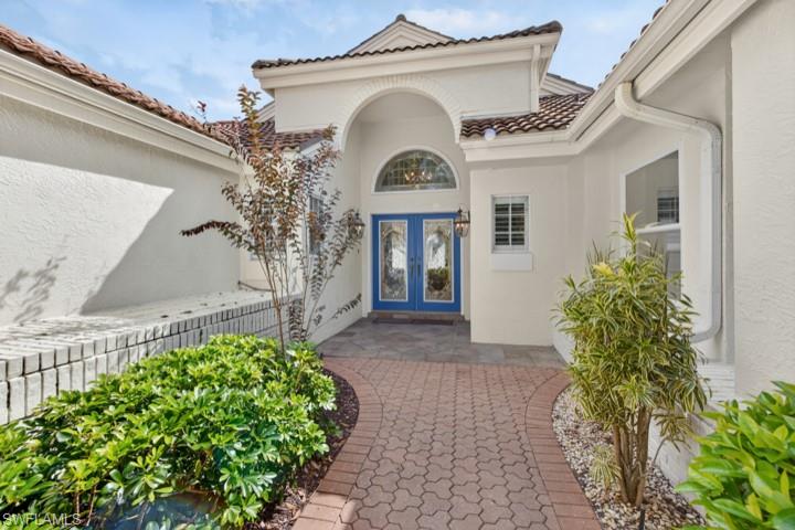 43 Grey Wing Point Naples, FL 34113 - Photo 23 of 50 Property entrance with stucco siding, a patio, and french doors
