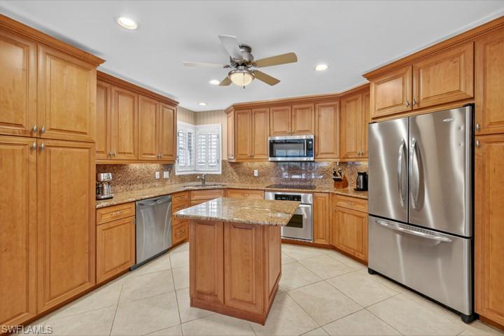 43 Grey Wing Point Naples, FL 34113 - Photo 27 of 50 Kitchen featuring stainless steel appliances, light stone countertops, decorative backsplash, light tile patterned floors, and recessed lighting