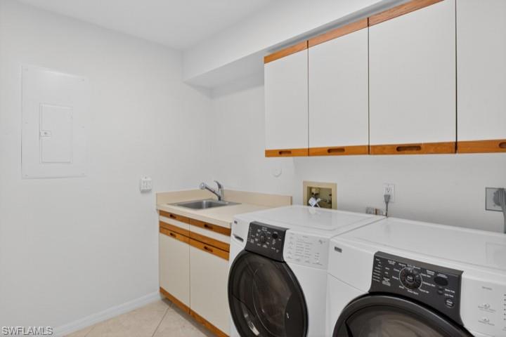 43 Grey Wing Point Naples, FL 34113 - Photo 32 of 50 Washroom featuring cabinet space, electric panel, washer and clothes dryer, and light tile patterned floors