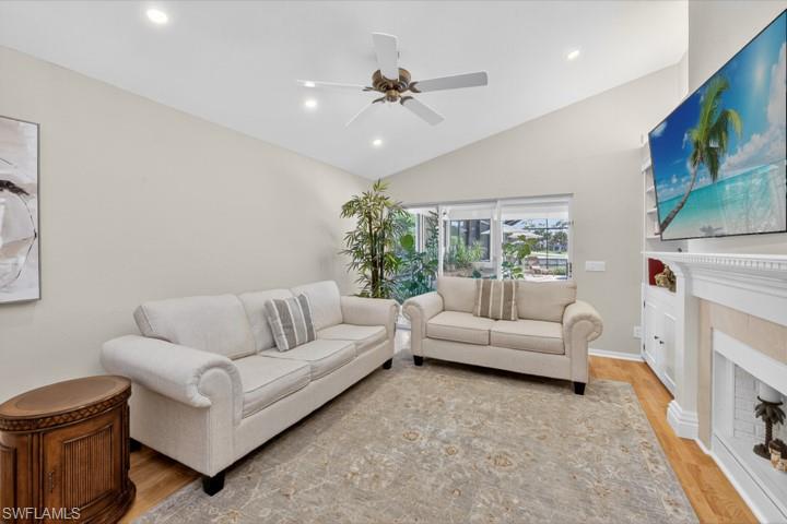 43 Grey Wing Point Naples, FL 34113 - Photo 33 of 50 Living area featuring light wood-type flooring, recessed lighting, a fireplace, lofted ceiling, and a ceiling fan