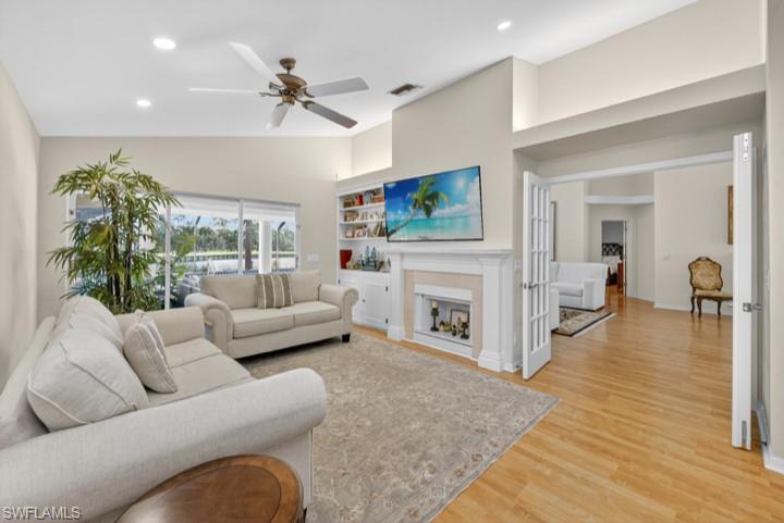 43 Grey Wing Point Naples, FL 34113 - Photo 38 of 50 Living area featuring recessed lighting, light wood finished floors, a fireplace, a ceiling fan, and lofted ceiling