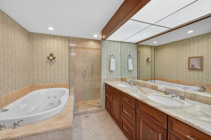 43 Grey Wing Point Naples, FL 34113 - Photo 40 of 50 Bathroom with a whirlpool tub, wallpapered walls, double vanity, a shower stall, and light tile patterned flooring
