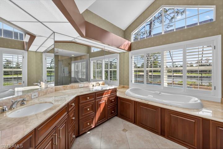 43 Grey Wing Point Naples, FL 34113 - Photo 42 of 50 Full bathroom with a garden tub, a stall shower, double vanity, light tile patterned floors, and high vaulted ceiling