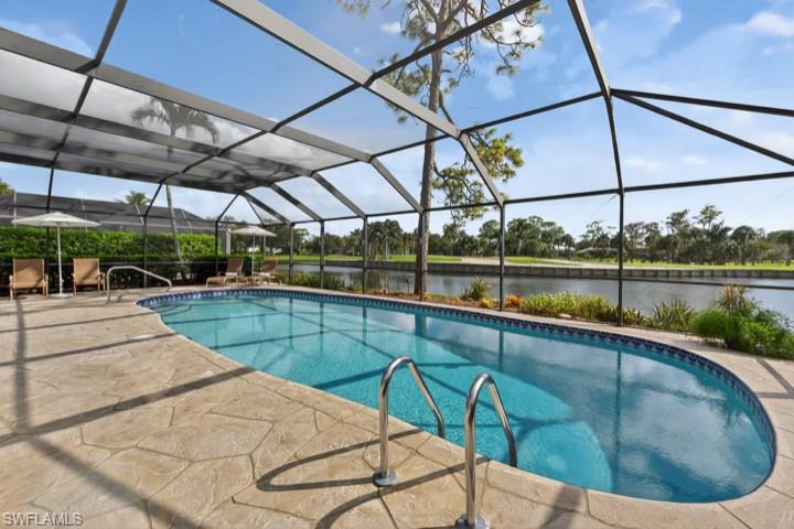 43 Grey Wing Point Naples, FL 34113 - Photo 49 of 50 Swimming pool featuring a water view, a lanai, a sunroom, and a patio area