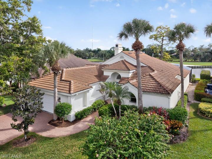 43 Grey Wing Point Naples, FL 34113 - Photo 6 of 50 View of front of home with an attached garage, a tile roof, stucco siding, driveway, and a chimney