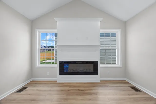 an empty room with windows and a fireplace