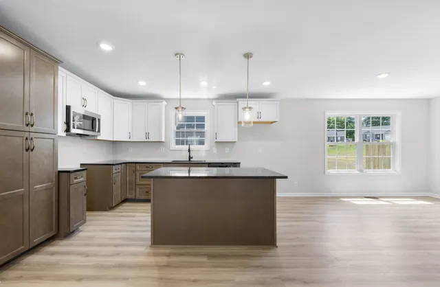 a kitchen with stainless steel appliances granite countertop a sink a stove and a refrigerator