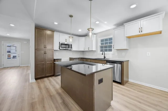 a kitchen with a sink window and stainless steel appliances