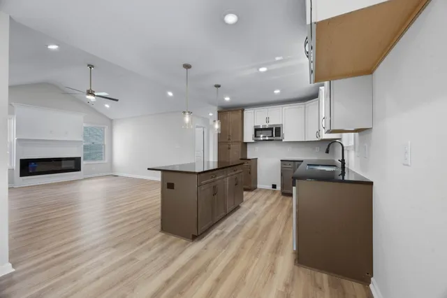 a kitchen with stainless steel appliances granite countertop a sink stove and a wooden floors