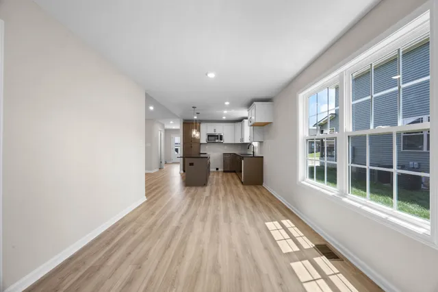 a view of a kitchen with wooden floor and windows