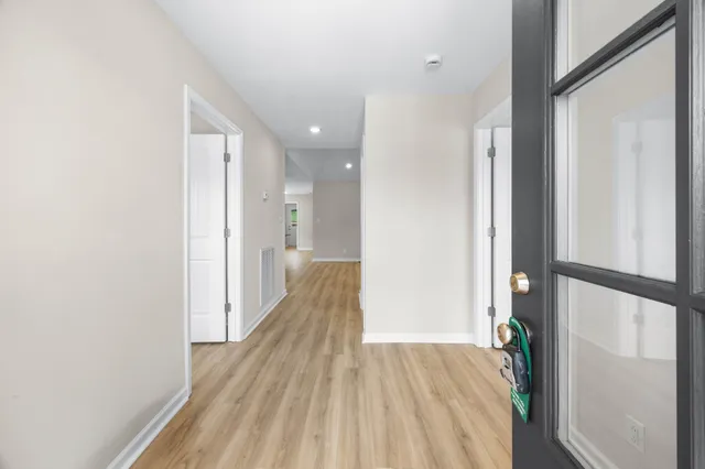 a view of a hallway with wooden floor and staircase