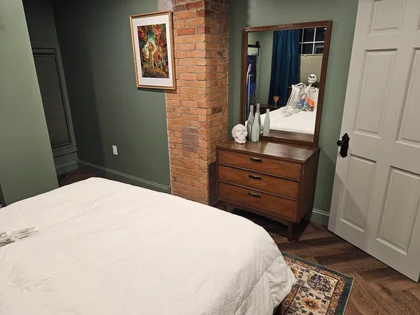 a bedroom with a bed and wooden floor